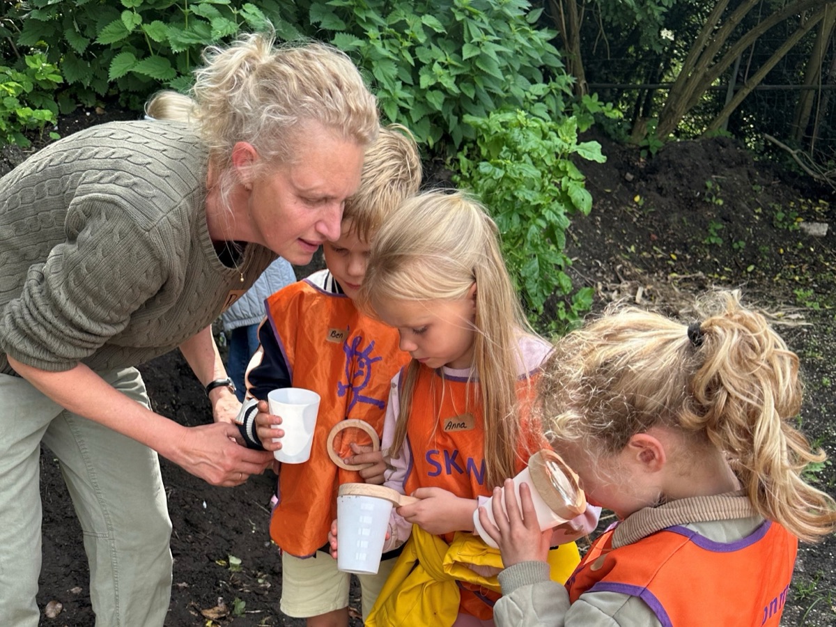 Renske schenkt thee in voor kinderen met bekertjes